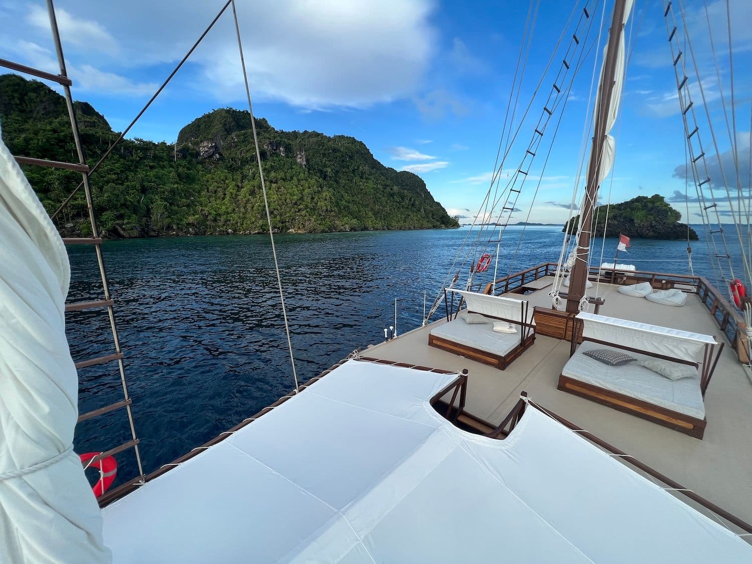 dewata top deck, green hills, blue sea water, bright blue sky