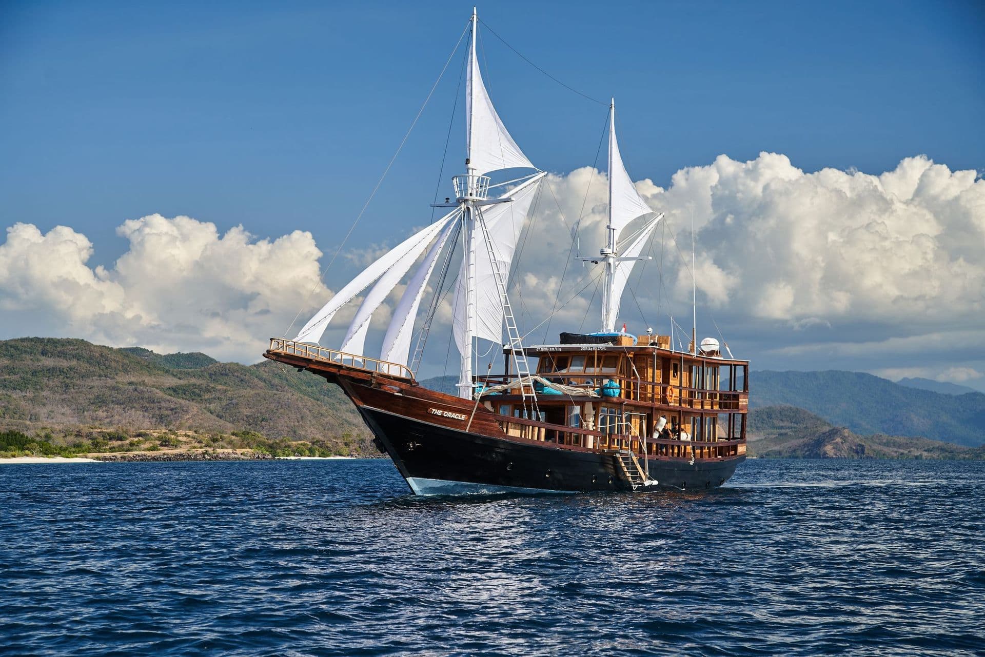 the oracle boat in a beautiful blue ocean, blue sky, big white sail