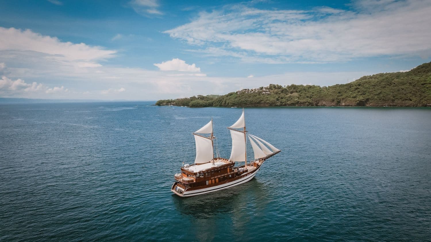 samsara samudra boat, white big sail, blue sea water, landscape view on the background