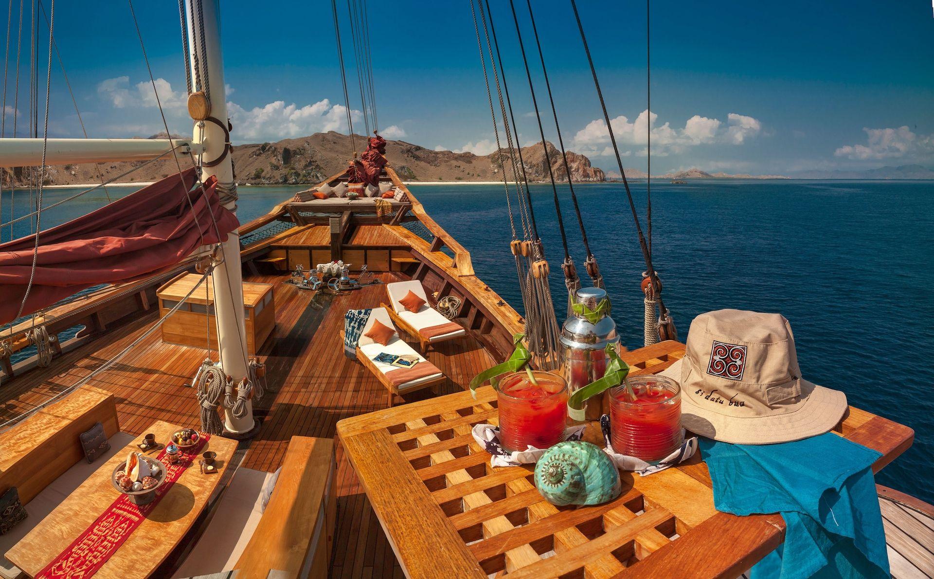 si datu bua boat with beautiful view at komodo, blue sky, blue sea, drink on the table, relaxing spot