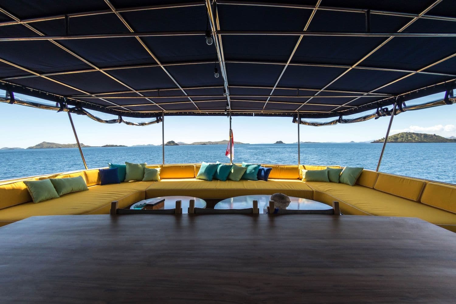 2 white round table at the center, yellow sofa, turquoise pillow on the sofa